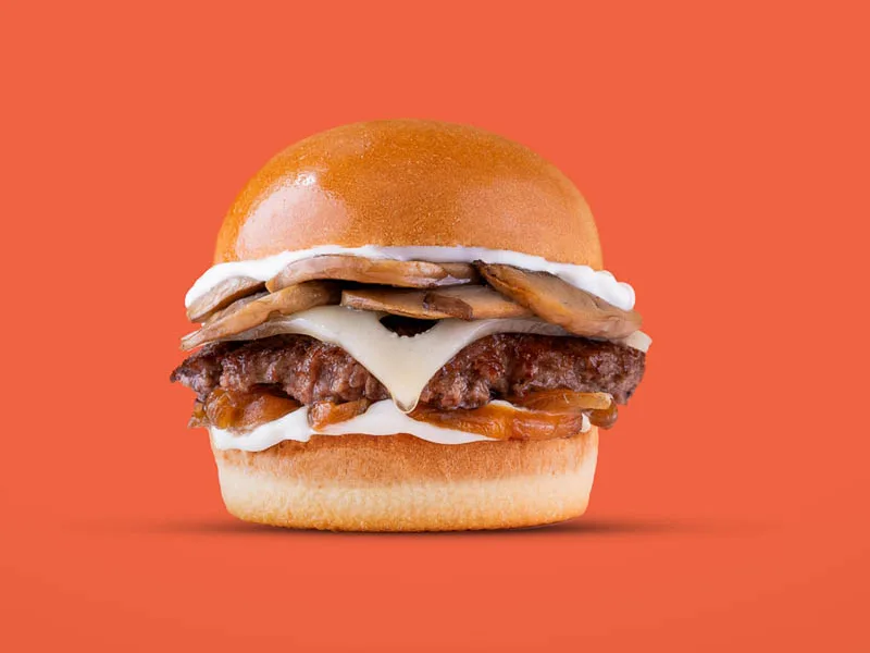 Burger product photography on an orange backdrop by Looptales